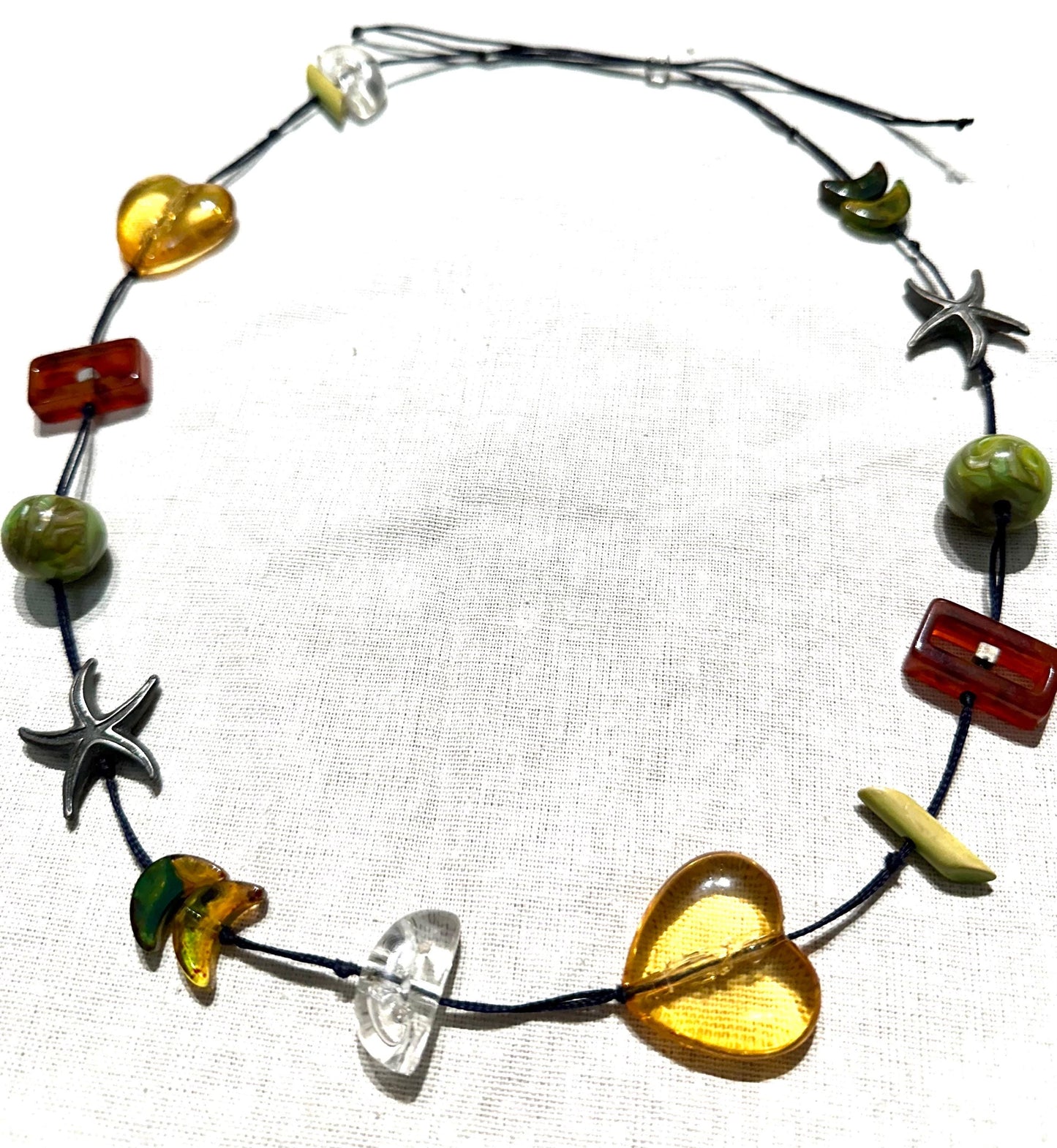 Hand made necklace with a variety of cute pendants, seastar, bakelite lucite and amber elements, unique piece