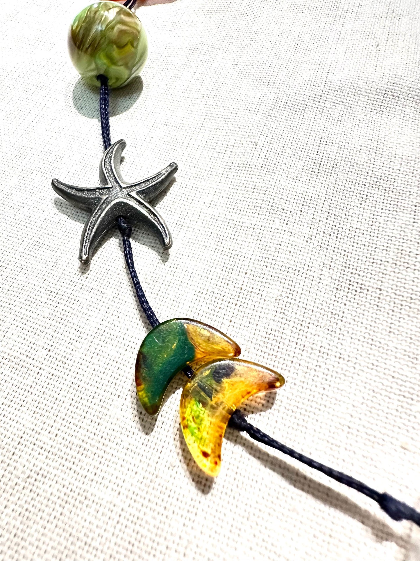 Hand made necklace with a variety of cute pendants, seastar, bakelite lucite and amber elements, unique piece