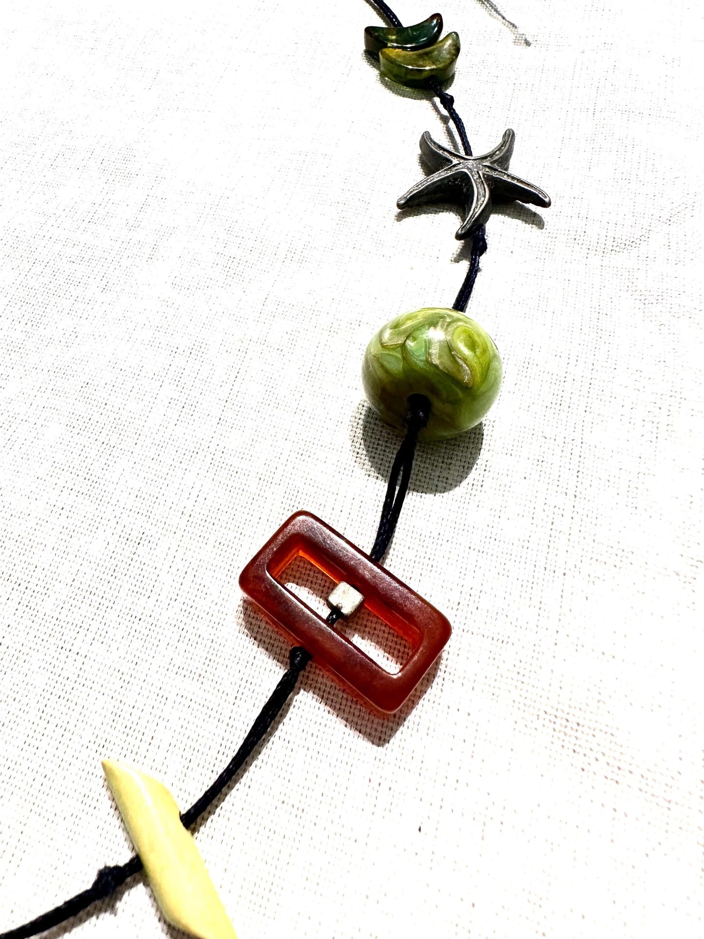 Hand made necklace with a variety of cute pendants, seastar, bakelite lucite and amber elements, unique piece